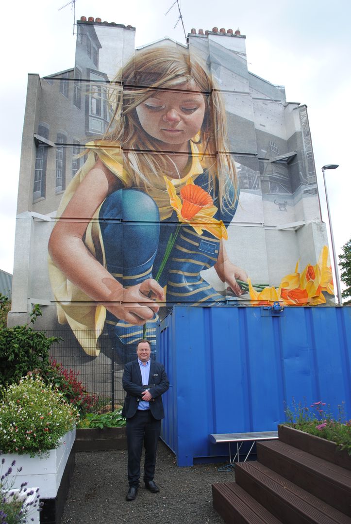 Chris Stephens MP standing at the Govan mural